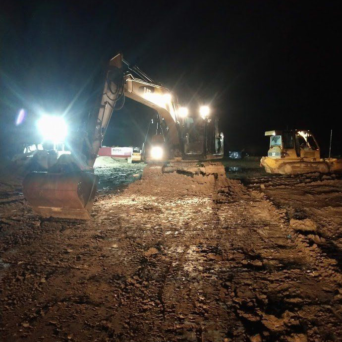 Excavator working at night time with its lights on
